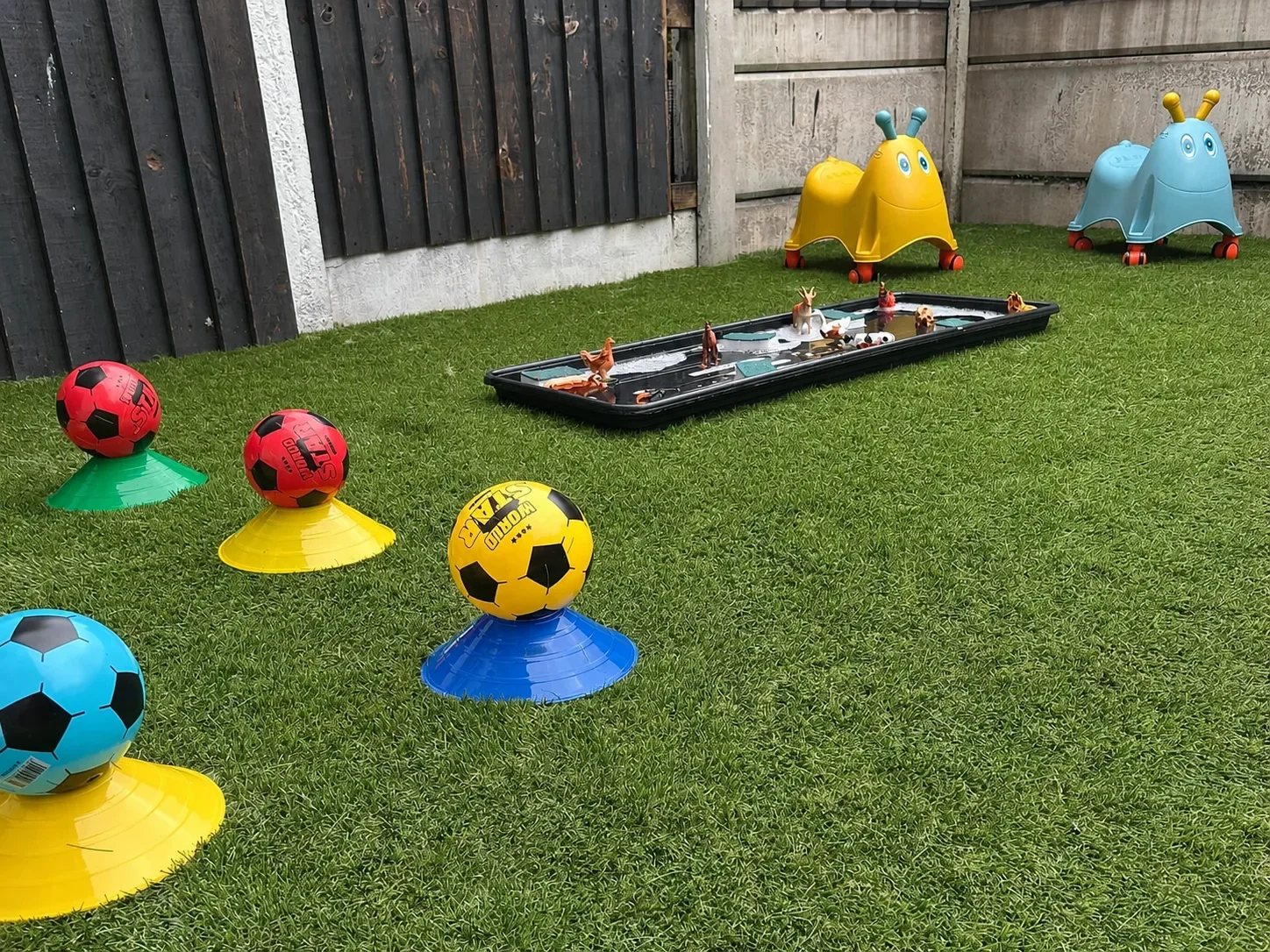 Colourful football targets and balls arranged as an outdoor obstacle course