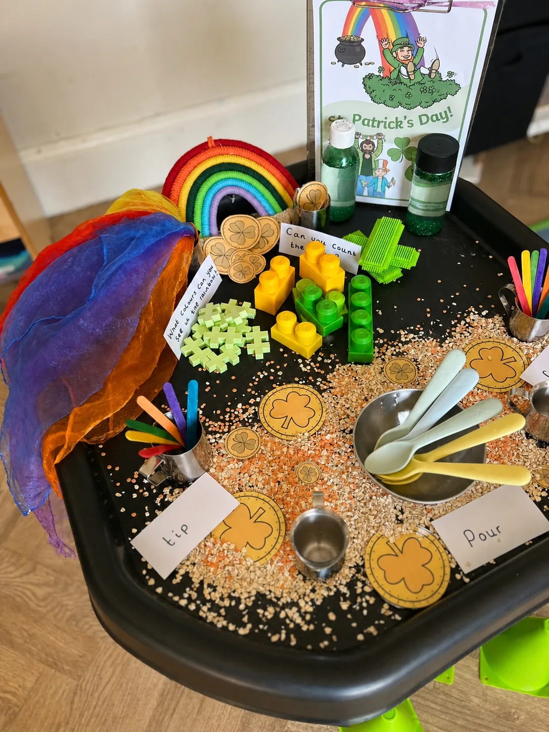 A sensory activity with grains, scoops, spoons and labelled invitations to pour and tip