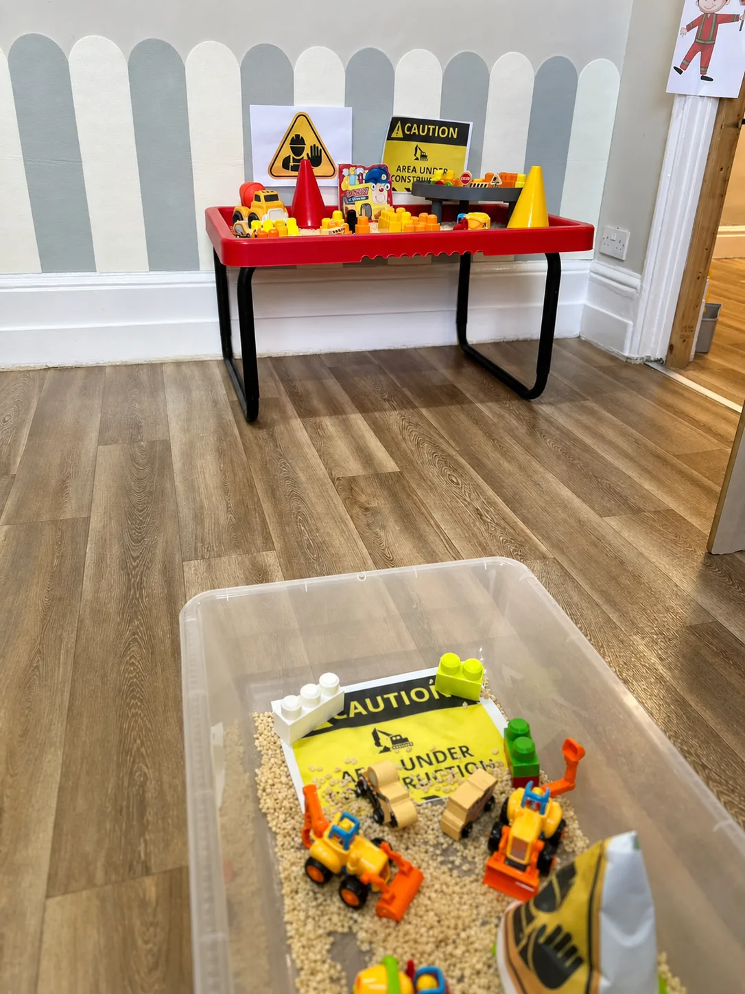 A construction-zone role-play setup with caution signs, vehicles and building resources