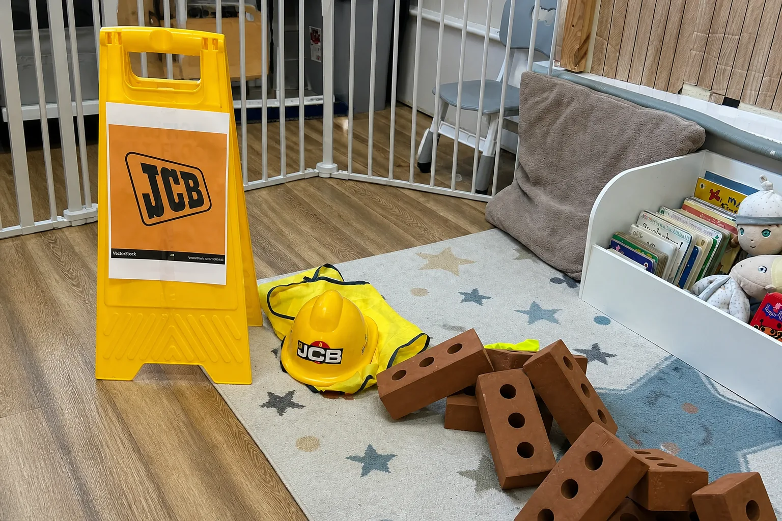 A JCB-themed imaginative play setup with soft bricks, a hard hat and construction signs